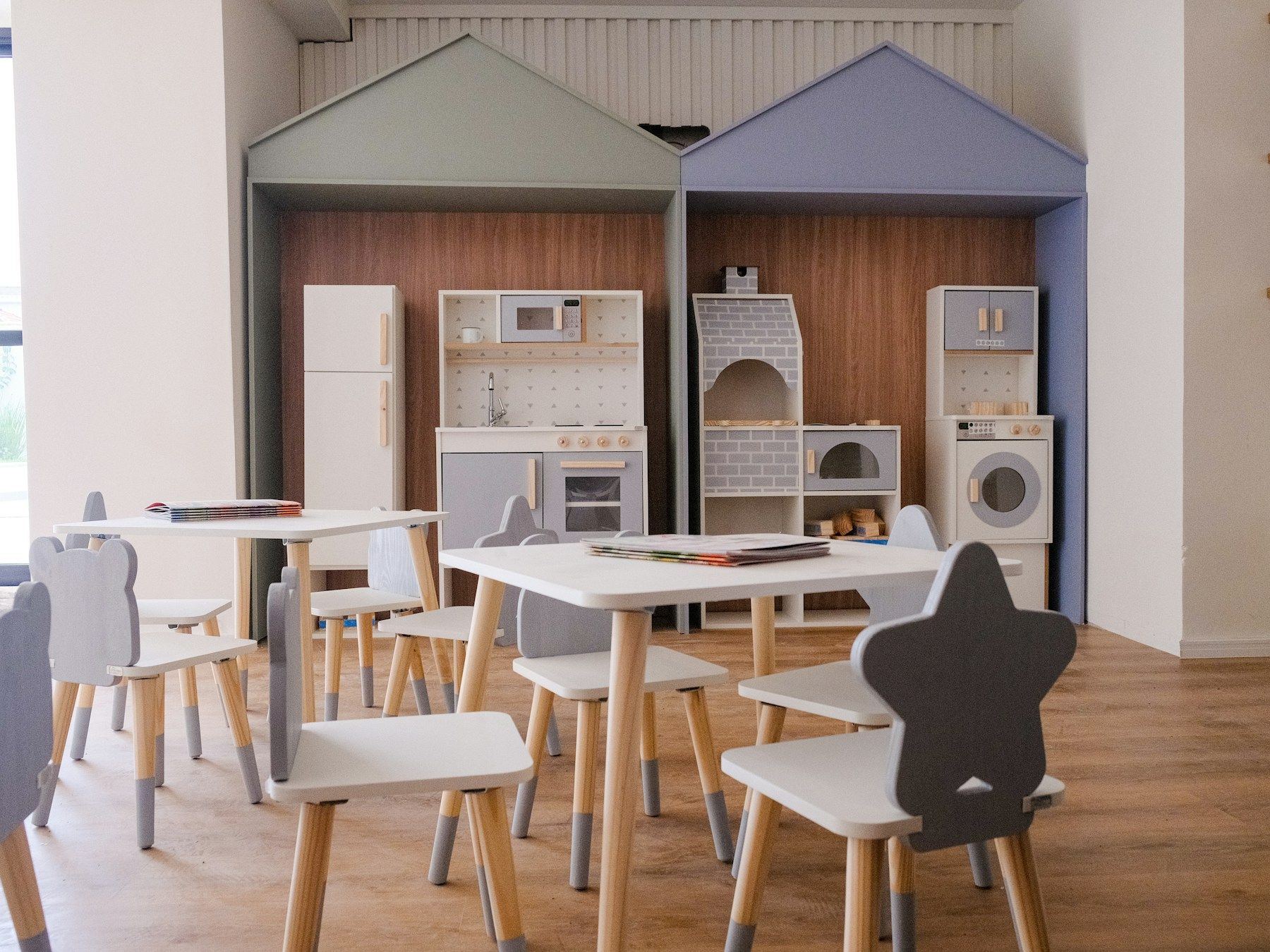 Aula educativa con tavoli, sedie e giochi in legno